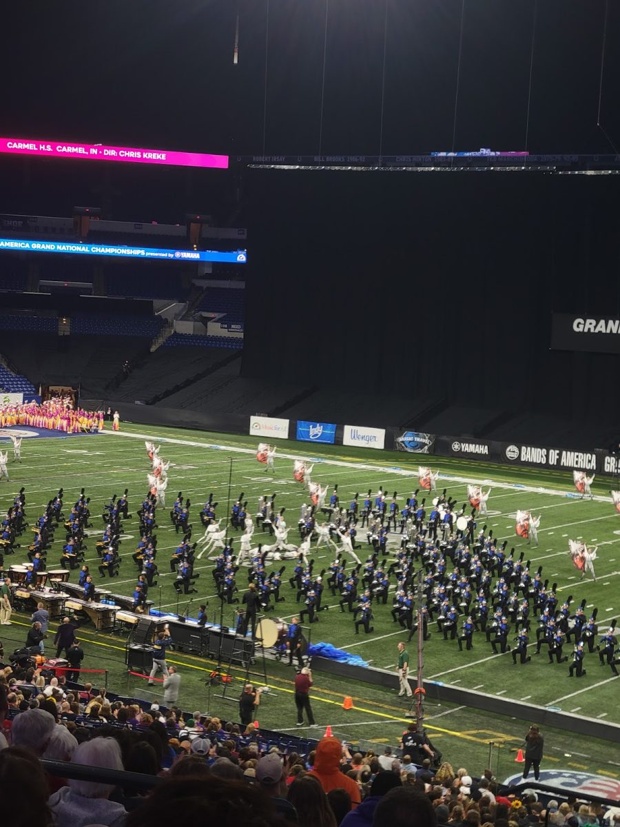 The Carmel High School marching band in a football stadium performing their show