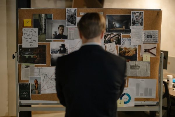 A person standing in front of a detective board