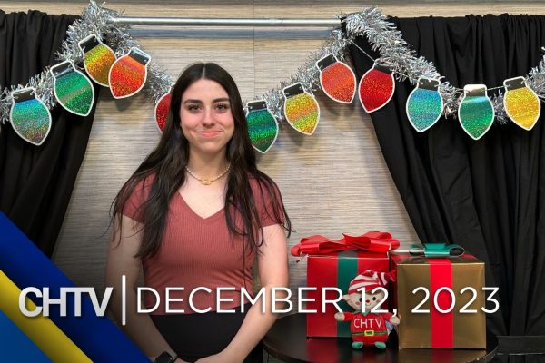 Coral standing at the entertainment set, with the text "CHTV: December 12, 2023" in front of her