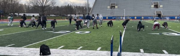 Track and Field students warming up on a football field 