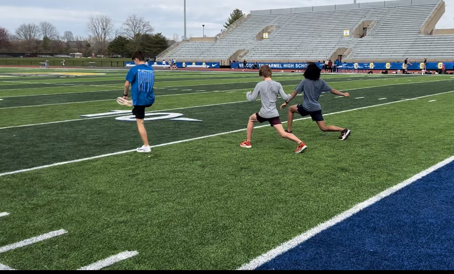 Students doing lunges on a football field