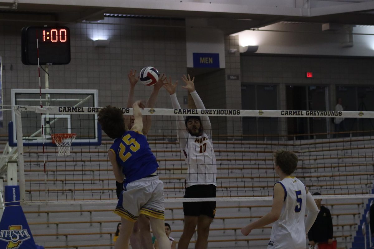 Carmel Boys Volleyball Player Jumps to Hit Ball Over the Net